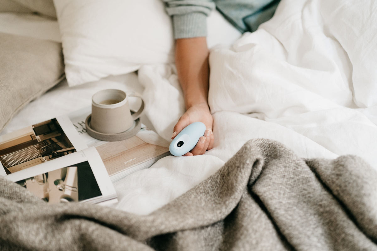 Hand holding moonbird in bed.