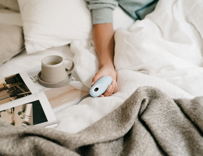 Hand holding moonbird in bed.